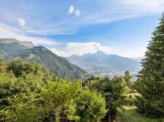 Experience breathtaking panoramic views from this stunning property, nestled amidst lush greenery and majestic mountains.