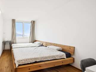 Experience comfort and style in this spacious bedroom featuring two twin beds with natural wood headboards.