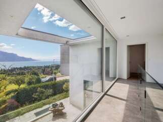 Experience breathtaking lake and mountain views from this modern home, featuring expansive floor-to-ceiling windows that flood the interior with natural light.