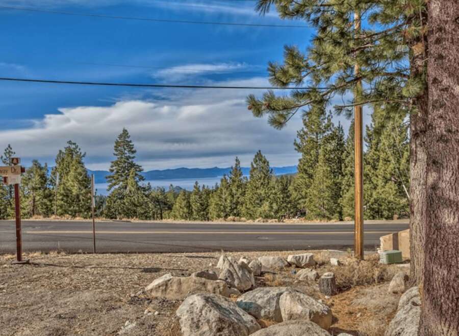 Discover your dream mountain retreat with stunning lake views! This prime location offers a serene escape surrounded by towering pine trees and a picturesque landscape.