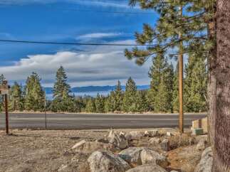 Discover your dream mountain retreat with stunning lake views! This prime location offers a serene escape surrounded by towering pine trees and a picturesque landscape.