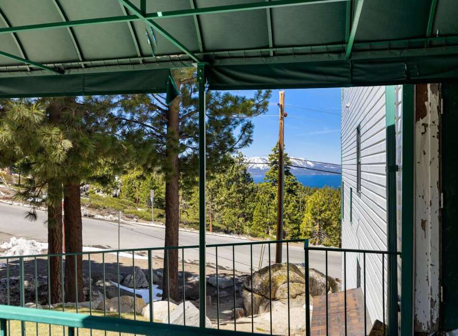 Enjoy breathtaking lake and mountain views from this property's covered porch, perfect for relaxing or entertaining.