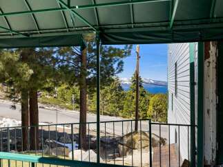 Enjoy breathtaking lake and mountain views from this property's covered porch, perfect for relaxing or entertaining.