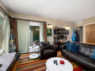 This cozy living room features a rich leather sofa and armchair, perfect for relaxing.