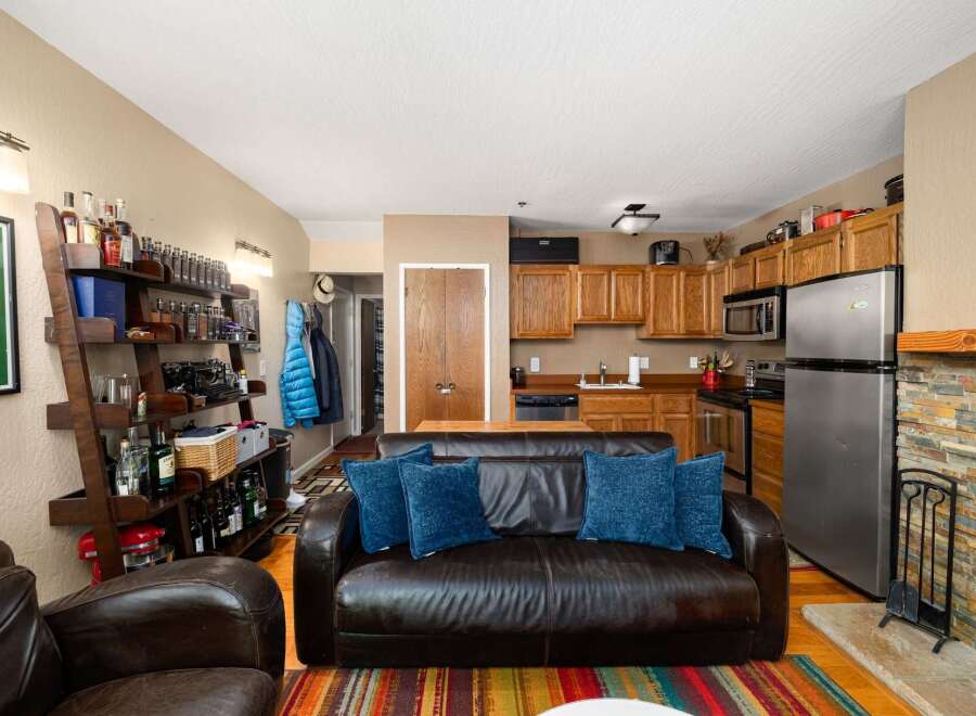 This cozy living space features a comfortable leather sofa adorned with plush blue pillows, perfect for relaxing after a long day.