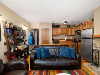 This cozy living space features a comfortable leather sofa adorned with plush blue pillows, perfect for relaxing after a long day.