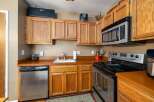 This cozy kitchen features warm, honey-toned wood cabinetry that provides ample storage.