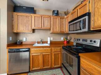 This cozy kitchen features warm, honey-toned wood cabinetry that provides ample storage.