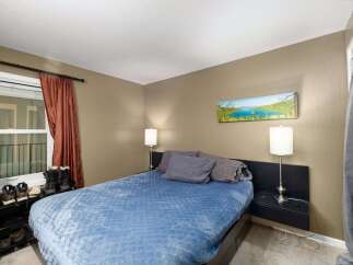 Discover comfort and style in this inviting bedroom, featuring a plush blue comforter on a modern bed.