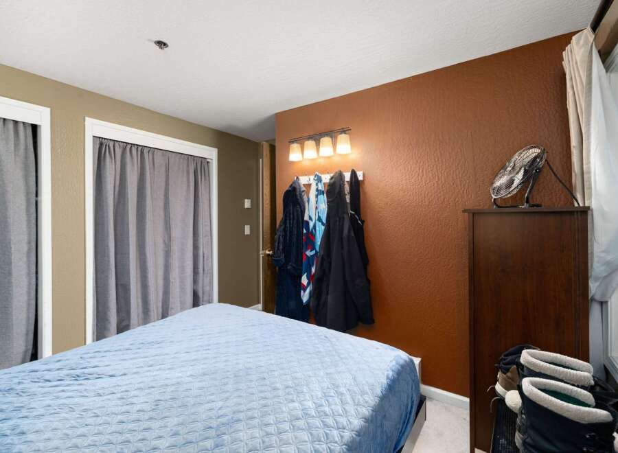 This cozy bedroom features a comfortable bed with a light blue quilted comforter, perfect for restful nights.
