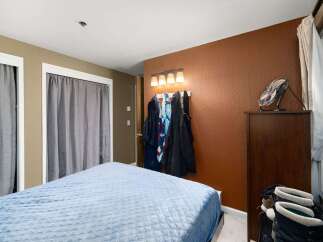 This cozy bedroom features a comfortable bed with a light blue quilted comforter, perfect for restful nights.