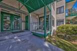 Discover comfortable living in this inviting property featuring a welcoming entrance with double green doors and a covered walkway.