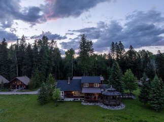 Experience the serene beauty of this mountain retreat, featuring a charming main lodge and two cozy cabins nestled amidst a lush forest.