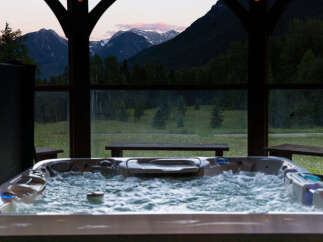 Experience ultimate relaxation with this stunning hot tub, offering breathtaking mountain views at dusk.