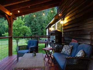 Enjoy the serene mountain views from this charming covered deck, perfect for outdoor dining and relaxation.