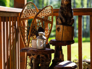 Embrace rustic charm on this inviting porch, featuring unique, handcrafted wooden furniture and decorative snowshoes.