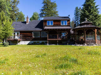 Experience serene living in this charming wooden home, nestled amidst a vibrant meadow of wildflowers and mature trees.