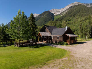 Escape to this charming rustic cabin nestled against a majestic mountain backdrop.