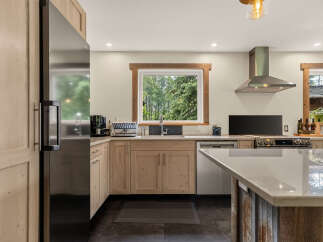 Experience the heart of this home with a stunning kitchen featuring light wood cabinetry and sleek stainless steel appliances.