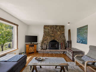 Cozy living room featuring a rustic stone fireplace with a wood-burning insert, perfect for chilly evenings.