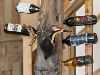This unique wine rack, carved from a natural wood log and shaped like a woodpecker, adds a rustic charm to any space.