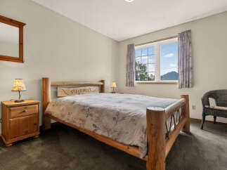 Experience rustic charm in this cozy bedroom, featuring a solid wood log bed with a 'Sleep Well' headboard.