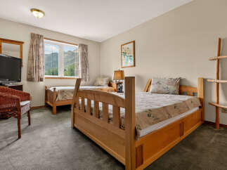 This charming bedroom features two comfortable wooden beds, perfect for accommodating guests or family.