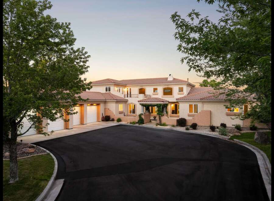 Discover this stunning Mediterranean-style estate, boasting a grand entrance with a covered portico and lush landscaping.