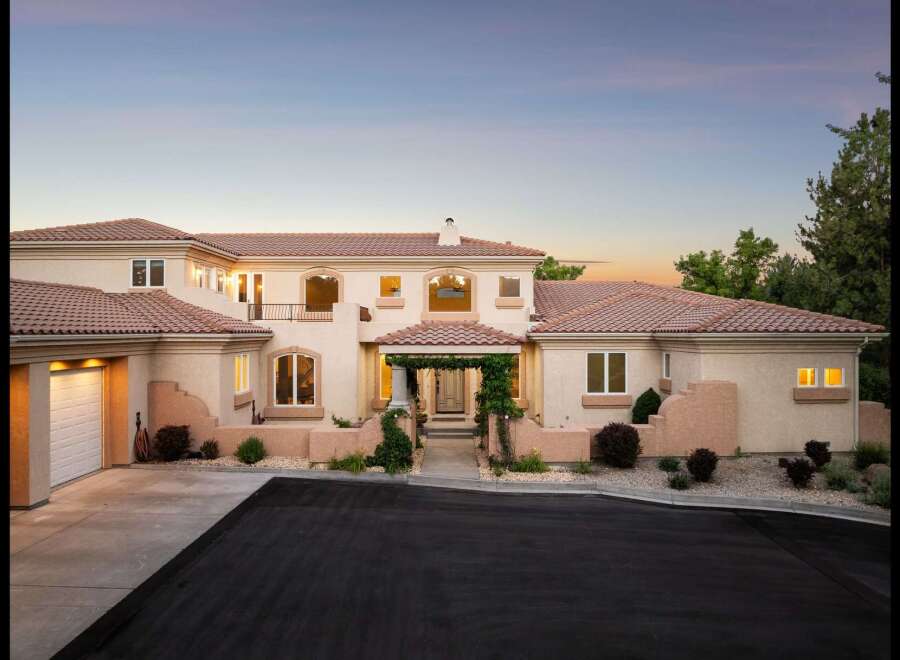 Experience luxury living in this stunning Mediterranean-style estate, featuring a grand entrance with a vine-covered pergola and elegant arched windows.