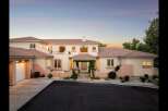 Experience luxury living in this stunning Mediterranean-style estate, featuring a grand entrance with a vine-covered pergola and elegant arched windows.