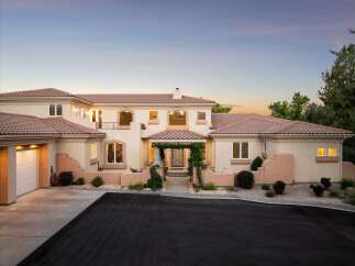 Experience luxury living in this stunning Mediterranean-style estate, featuring a grand entrance with a vine-covered pergola and elegant arched windows.