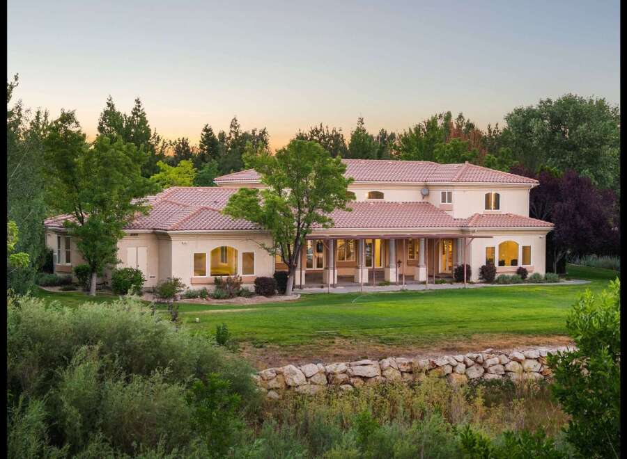 This expansive estate offers a luxurious Mediterranean-style residence with a sprawling lawn and mature trees, perfect for outdoor entertaining.