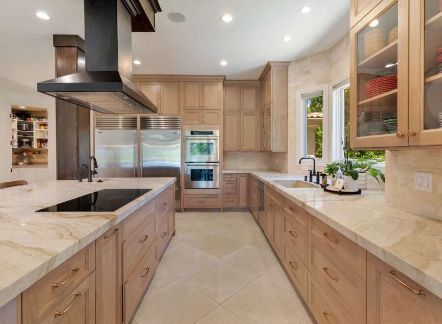 Experience luxury in this stunning chef's kitchen, featuring a large island with a built-in cooktop and ample seating.