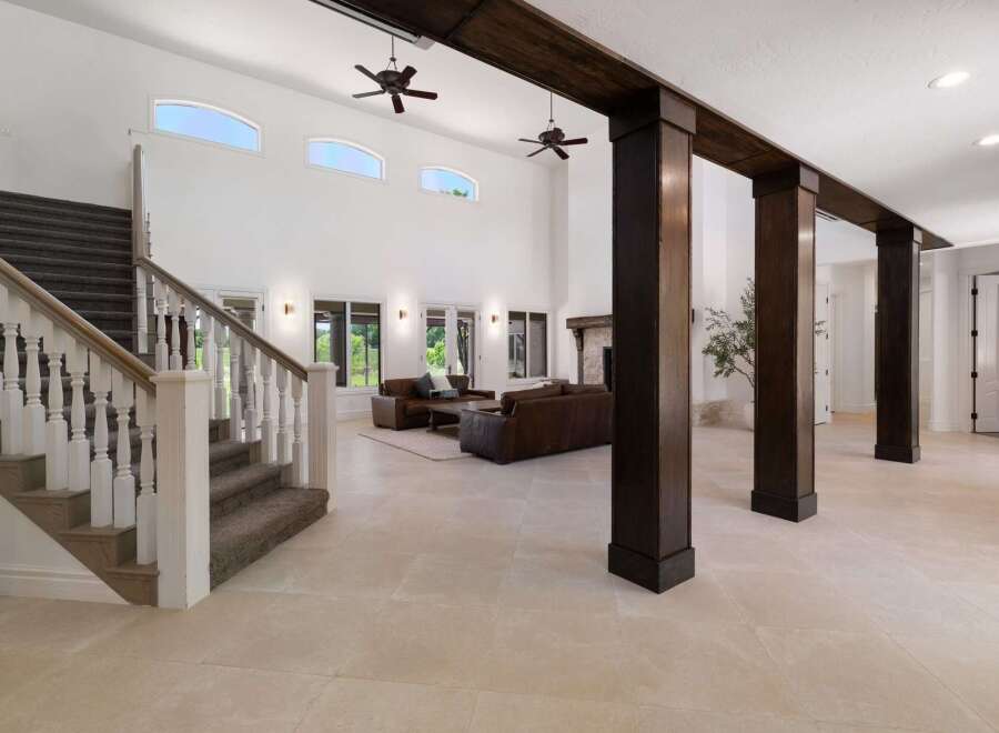 Experience grand living in this spacious home featuring a dramatic two-story foyer with a sweeping staircase and elegant white balusters.
