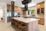 Experience luxury in this stunning gourmet kitchen, featuring a large marble island with a built-in cooktop and seating.