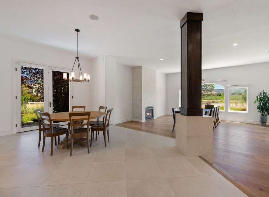 Experience elegant dining in this spacious open-concept home, featuring a charming wooden dining set perfect for family gatherings.