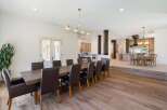 Experience elegant dining in this spacious home, featuring a large wooden dining table with plush leather chairs perfect for hosting.