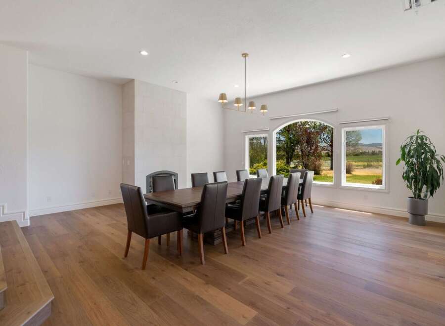 Experience elegant dining in this spacious room, featuring a large wooden table surrounded by plush leather chairs, perfect for hosting gatherings.