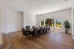 Experience elegant dining in this spacious room, featuring a large wooden table surrounded by plush leather chairs, perfect for hosting gatherings.