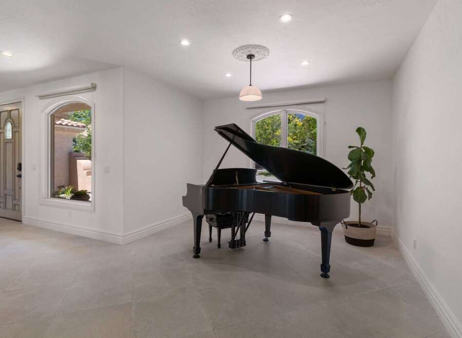 Experience elegance and musicality in this stunning room, featuring a grand piano as the centerpiece.