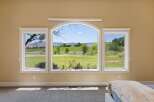Experience breathtaking panoramic views from this stunning property, featuring a large arched window complemented by two side windows.