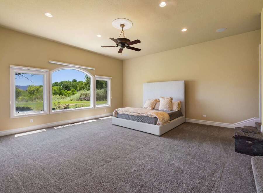 Experience serene living in this spacious master bedroom, featuring a king-sized bed with a plush headboard and luxurious bedding.
