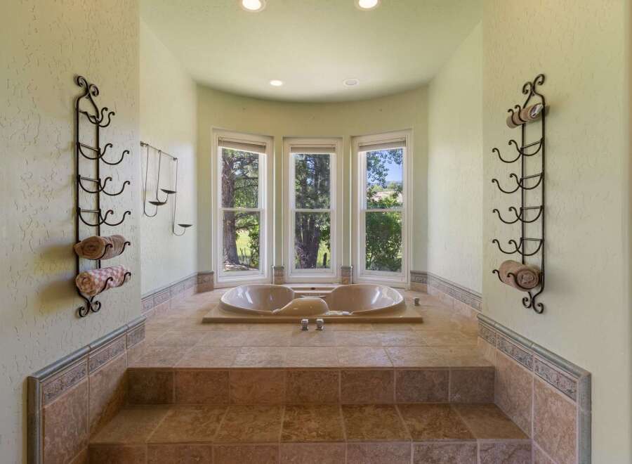 Indulge in relaxation in this luxurious bathroom featuring a spacious sunken jacuzzi tub.