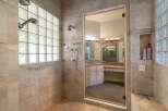 Experience luxury in this spacious bathroom featuring a walk-in shower with multiple shower heads and a large glass enclosure.