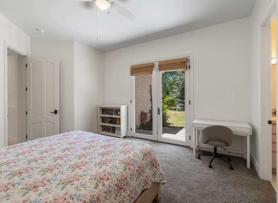 This charming bedroom offers a peaceful retreat with a floral-patterned bedspread and a convenient desk area.