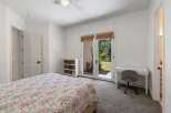 This charming bedroom offers a peaceful retreat with a floral-patterned bedspread and a convenient desk area.