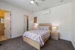 This inviting bedroom features a comfortable queen-size bed with a floral comforter and matching pillows, complemented by two wooden nightstands with lamps.