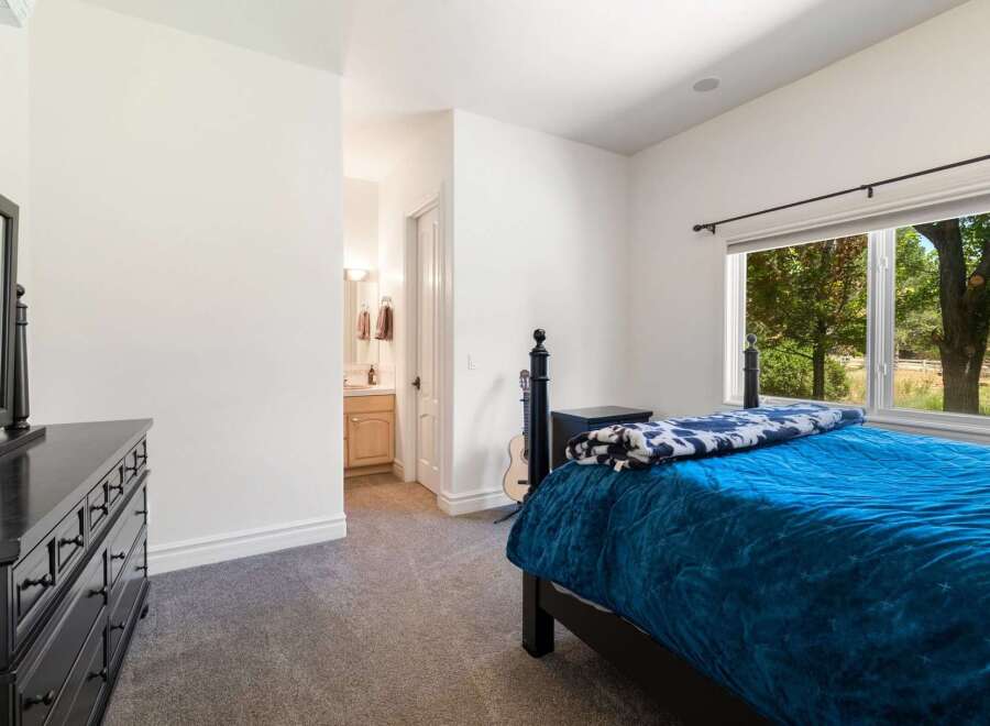 This bedroom offers a comfortable and stylish retreat, featuring a plush blue comforter and a decorative throw blanket.