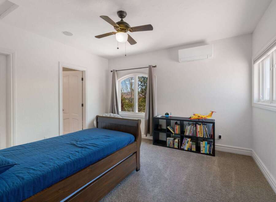 Discover this charming bedroom featuring a comfortable wooden bed with a blue quilted comforter, perfect for relaxation.