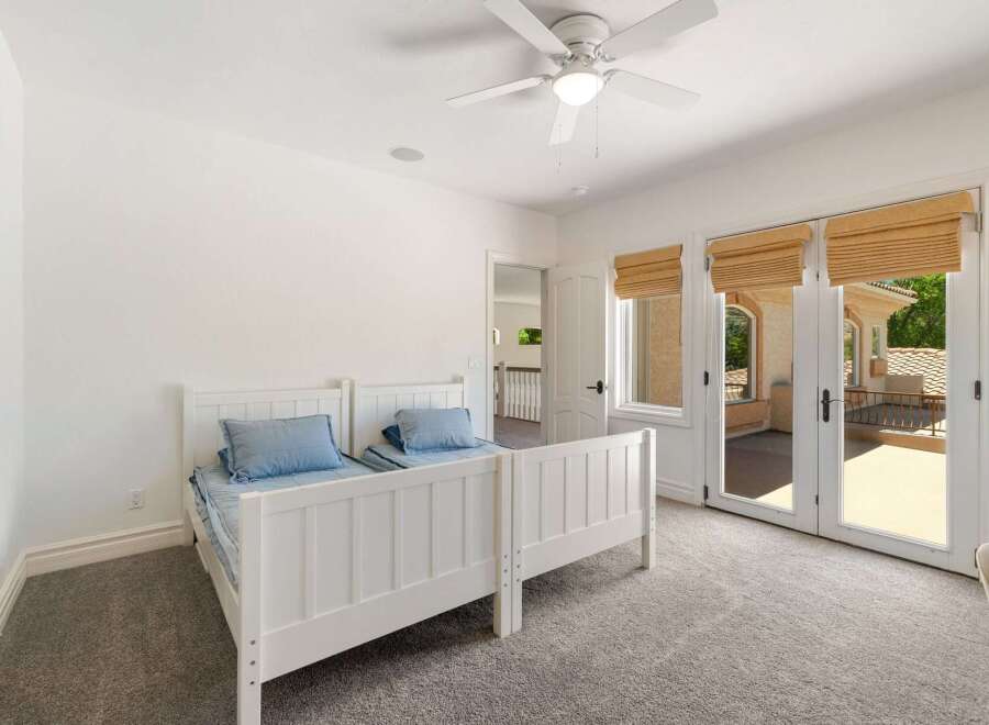 This charming bedroom features two twin beds with blue bedding, perfect for guests or children.